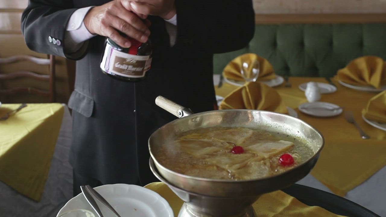 Chef in black suit cooking with dramatic fire